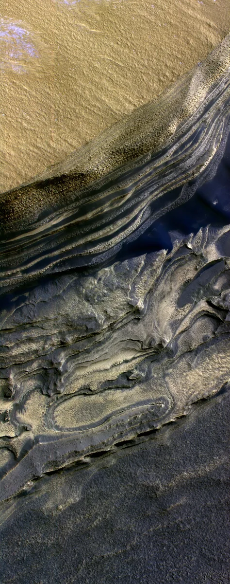 This false-color subframe shows the north polar layered deposits at top and darker materials at bottom exposed in a scarp at the head of Cha